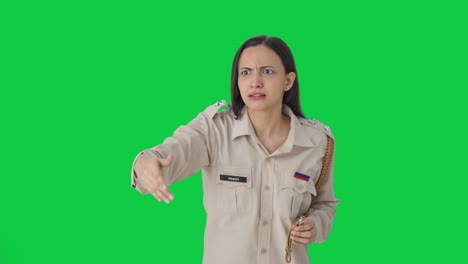 angry indian female police officer using whistle to call someone green screen