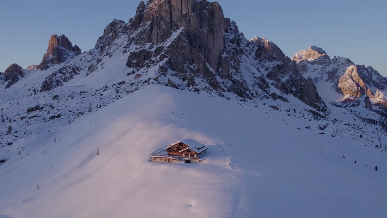 Snowy Dolomites with mountain lodge and peaks, Passo di Giau, Belluno, Italy