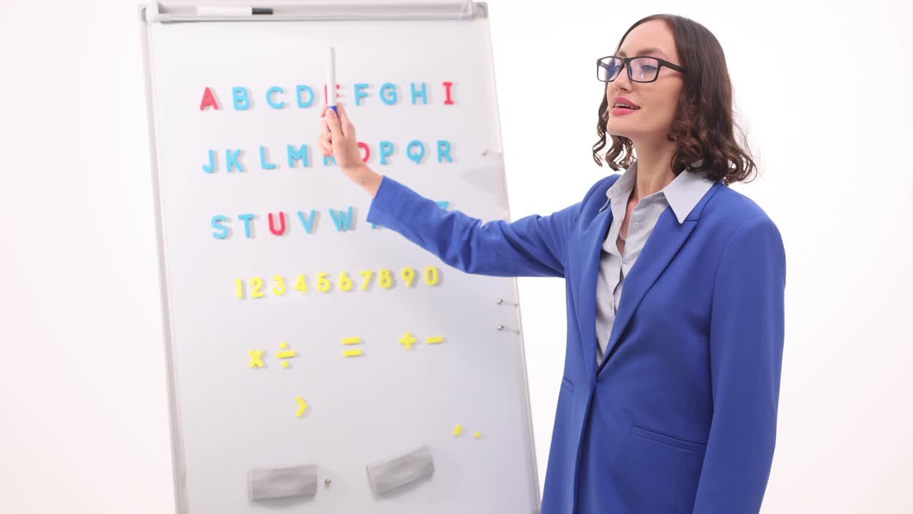 Teacher Explaining Alphabet and Numbers on Whiteboard