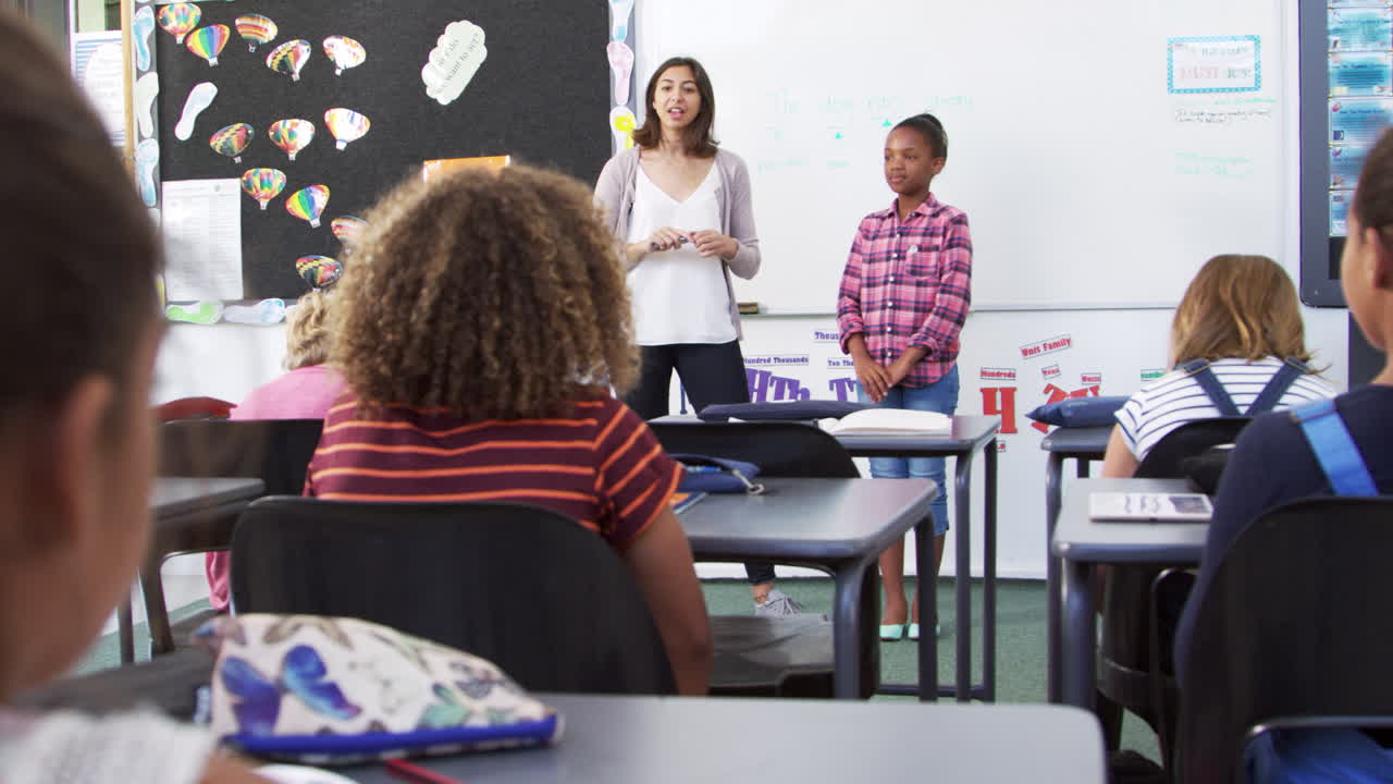 maestro y alumno presentando a la clase de escuela primaria