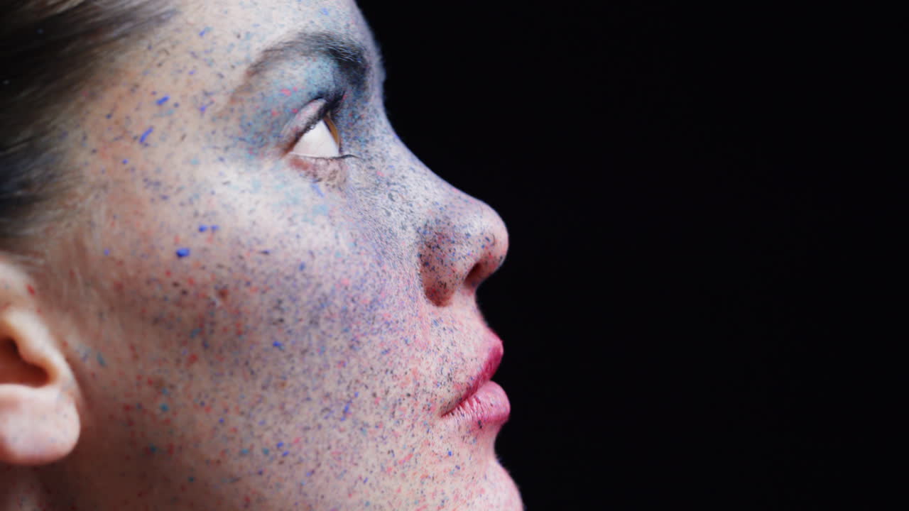 retrato de una mujer hermosa con maquillaje de pintura facial azul buscando arte corporal exótico en una artista femenina atractiva expresión creativa luz desvaneciéndose en un fondo oscuro