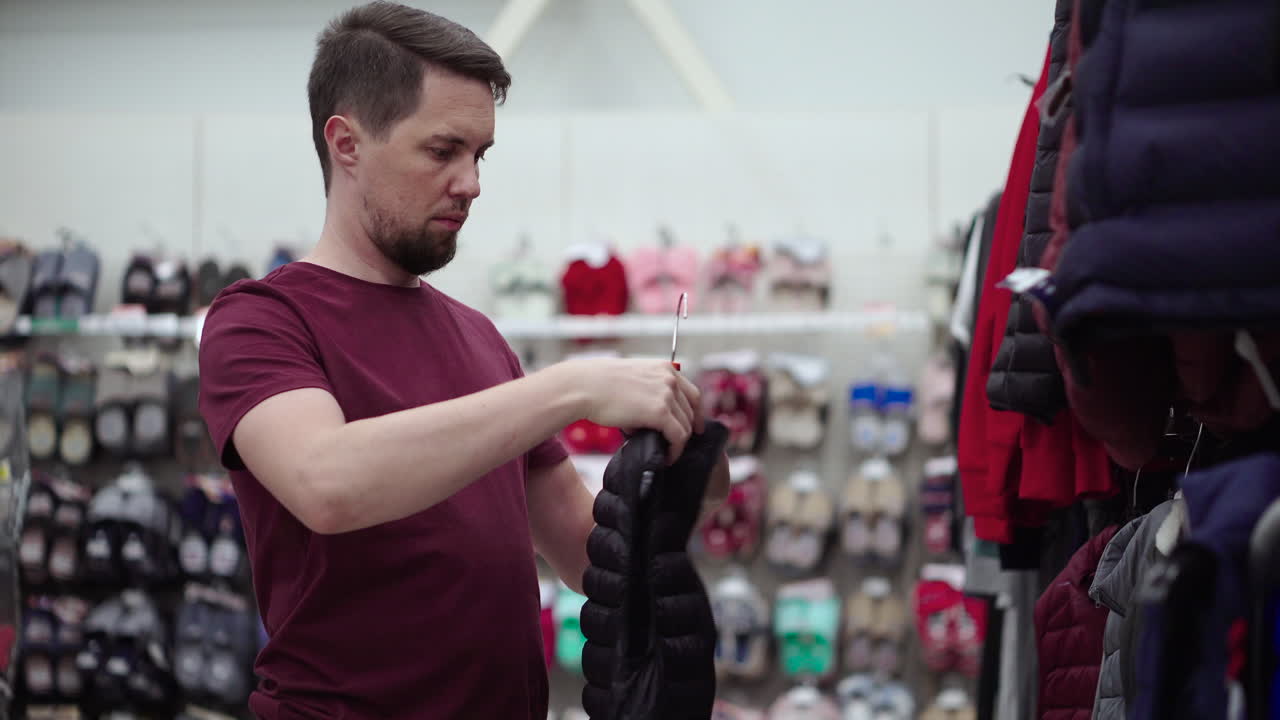 hombre intentando un chaleco en una tienda de ropa
