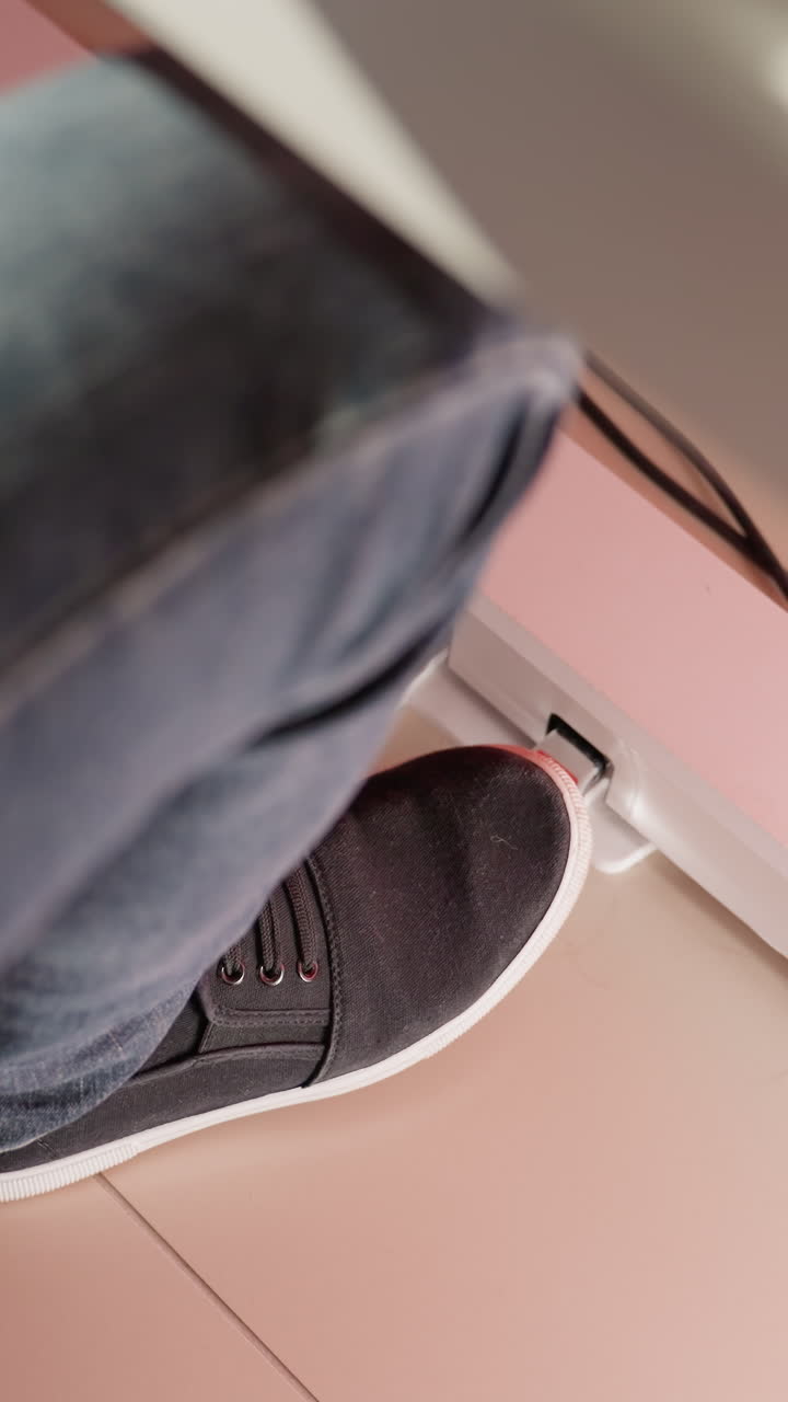 피아노 페달 위에 놓인 검은 신발과 블루 진즈를 입은 발의 클로즈업 오버헤드 이 조용히 조명되어 평온하고 집중된 분위기를 만니다.