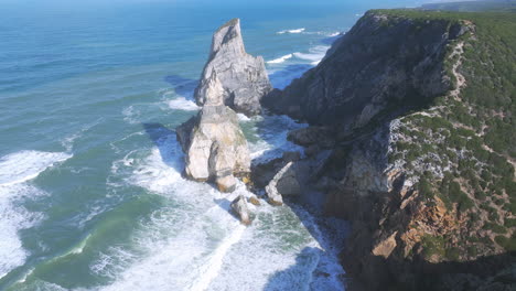 Stunning aerial perspective of Praia da Ursa, Portugal, with bright morning sunlight over the Atlantic coast.