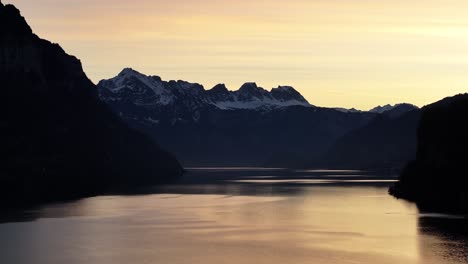 Goldene-Dämmerung-über-Dem-Walensee,-Die-Silhouette-Der-Churfirsten.-Schweiz-Luftaufnahme