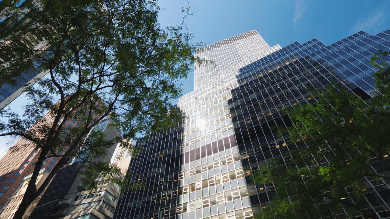 el sol se refleja en el cristal de un rascacielos en wall sreeet en nueva york