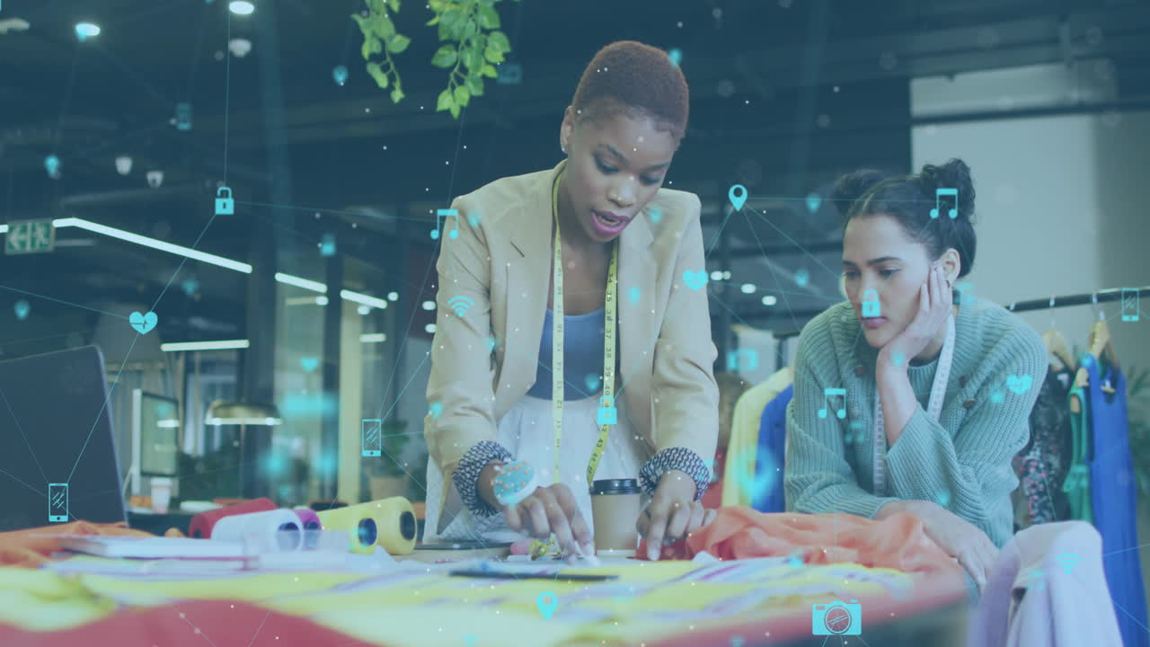 Animation of multiple icons connected with lines over diverse fashion designers discussing ideas