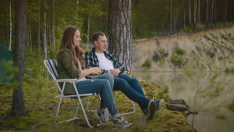 Un-Par-De-Hombres-Y-Mujeres-Adultos-Descansan-En-La-Naturaleza-En-El-Fin-De-Semana-De-Verano-O-Otoño-Acampando-En-El-Bosque,-La-Gente-Está-Sentada-En-Sillones