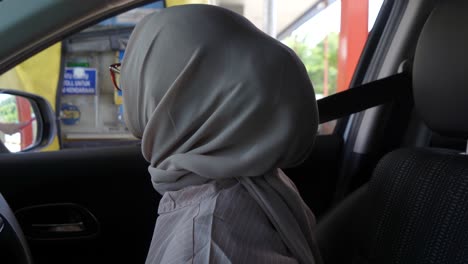 happy young muslim woman driving a car on a sunny day