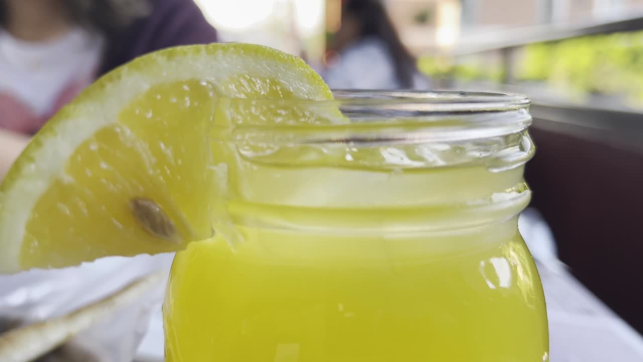 은 날 야외에서 레몬 조각이 있는 메이슨 항아리 안의 상쾌한 레모네이드