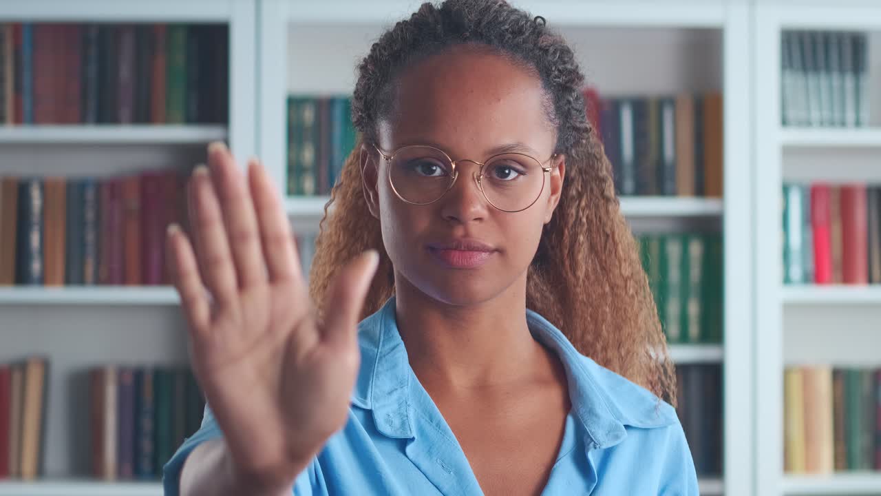 Young determined bold african american woman making stop gesture stand indoors