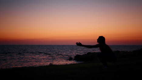 woman silhouette at sunset by the ocean