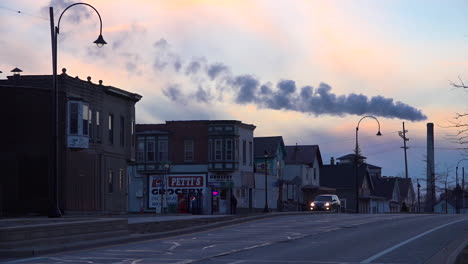 a smokestack belches pollution over michigan city indiana at dusk