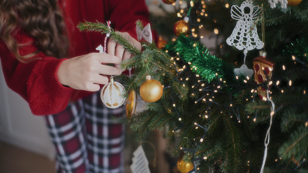 mujer colgando joyas en el árbol de navidad en casa