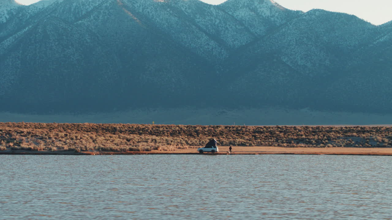 autocaravana en la naturaleza junto al lago y las montañas en el fondo, antena
