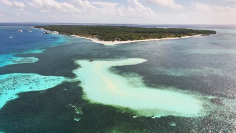 aerial perspective of candaraman sand bar in balabac, palawan, philippines, featuring turquoise shallows, surrounding coral reefs, and dense forest coastline under a partly cloudy sky
