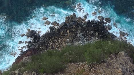 Aerial-view-of-rocky-cliff-and-waves-crashing-off-north-coast-of-Maui,-Hawaii