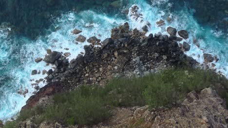 aerial view of rocky cliff and waves crashing off north coast of maui, hawaii