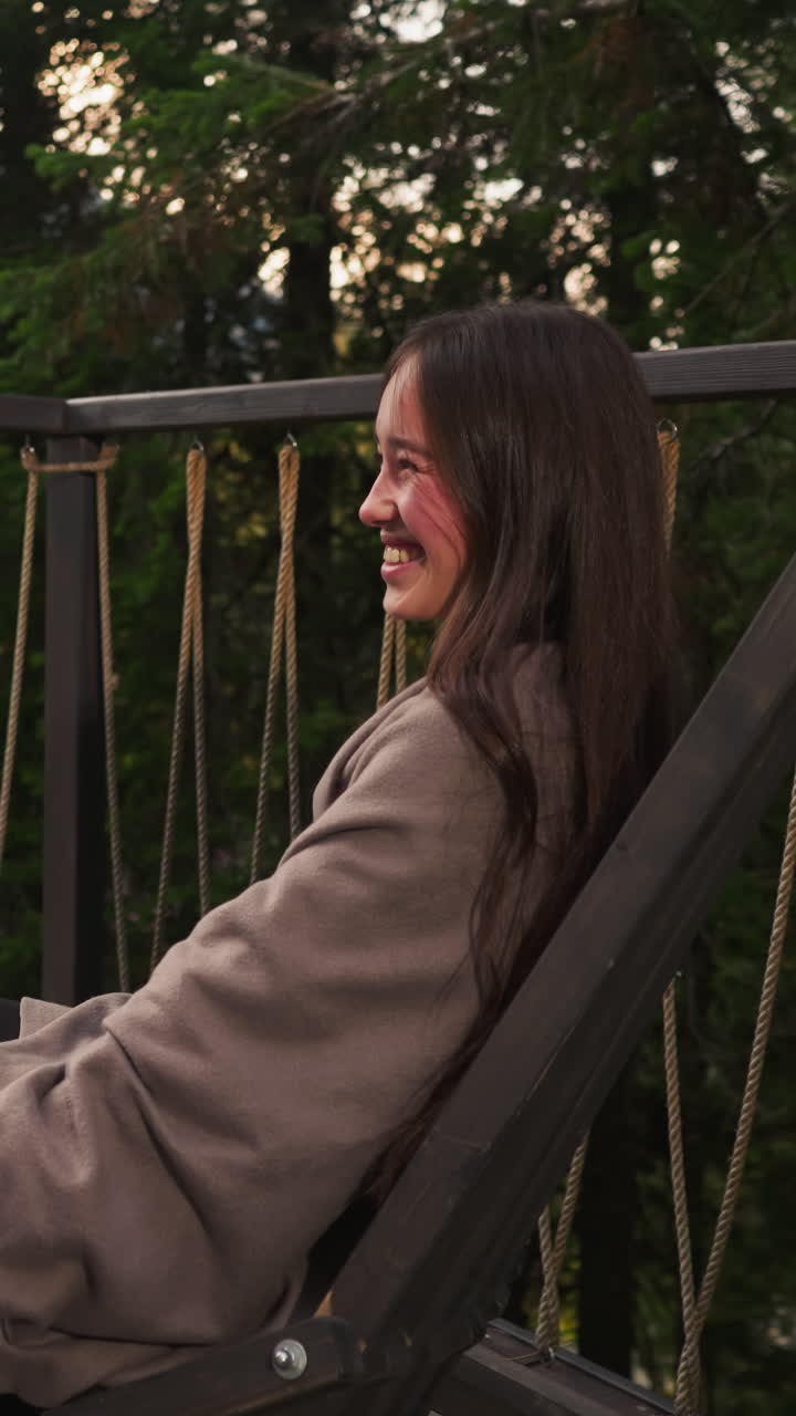 Couple laughs together on hotel terrace Man with woman cherishes moment in glamping paradise among forest area. Enchanting and romantic getaway at twilight