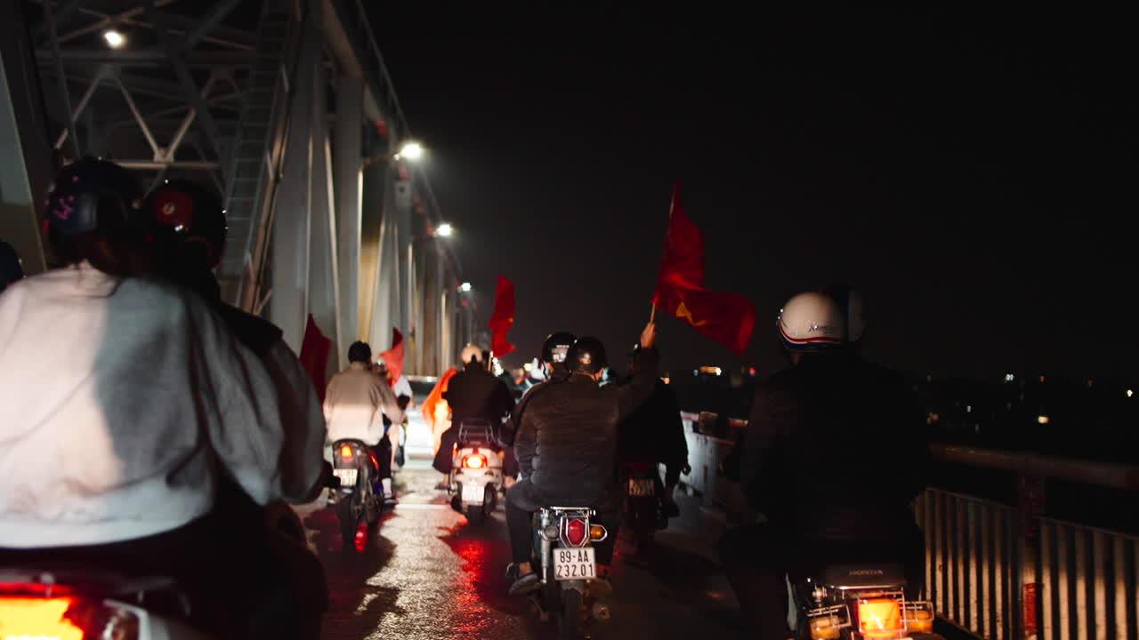 Motorcycle procession with Vietnamese flags at night