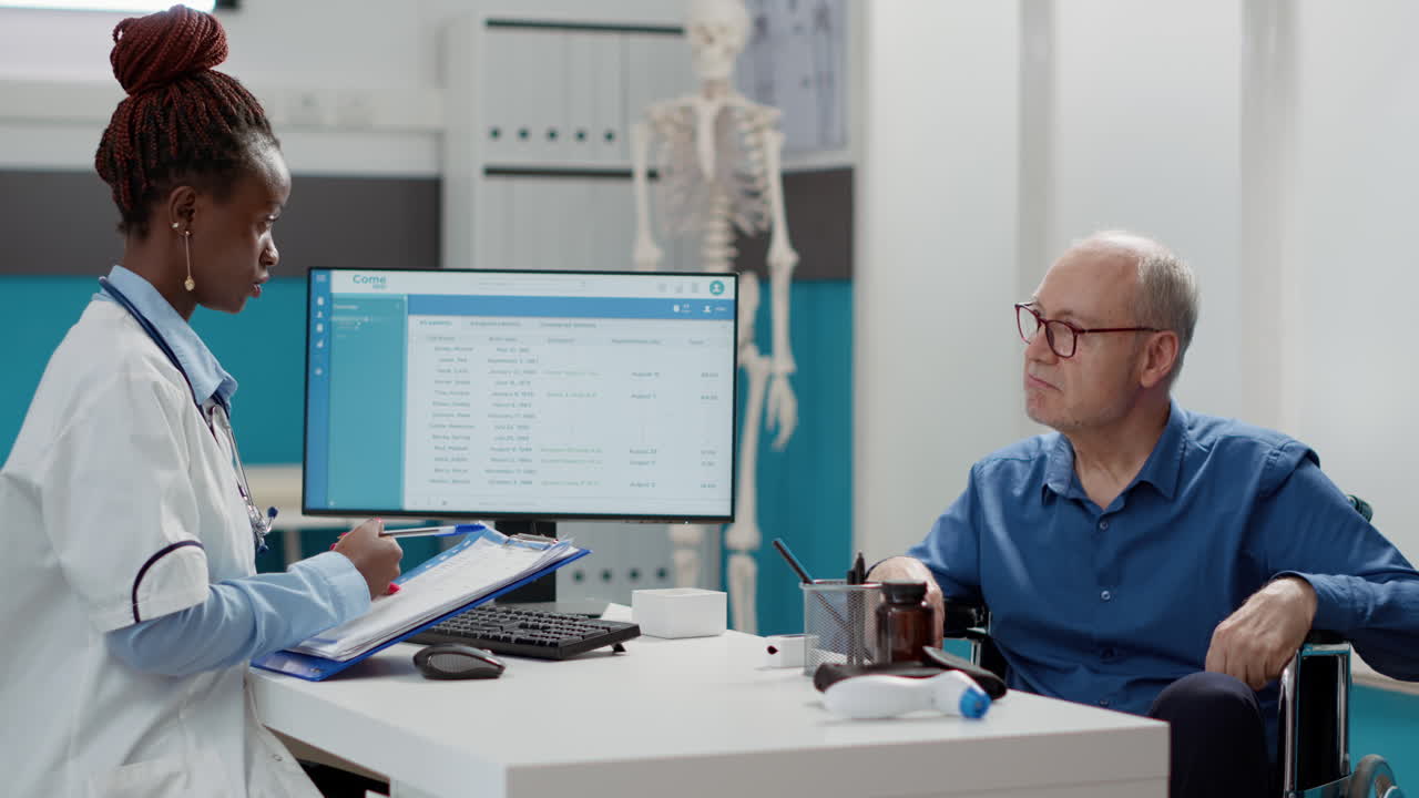 Doctor consulting with elderly patient in wheelchair at clinic