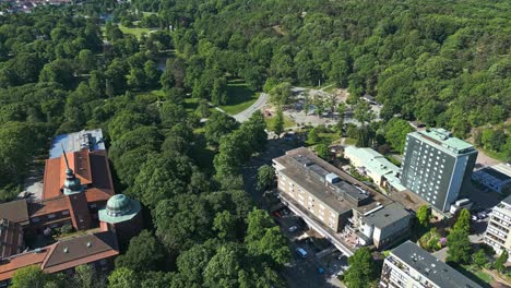 Flying-over-Plikta-playground-in-Slottsskogen-city-park-and-to-the-bottom-left-is-the-Gothenburg-Museum-of-Natural-History-in-Gothenburg,-Sweden