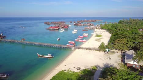 Aerial-flight-over-tropical-beach-towards-stunning-ocean-in-Mabul,-Malaysia