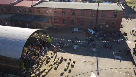 dynamic aerial view of people watching a country live concert in an industrial looking place