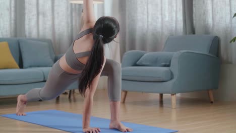 joven atleta asiática haciendo ejercicio, estirándose y practicando yoga en casa. estilo de vida saludable, fitness, bienestar y concepto de atención plena