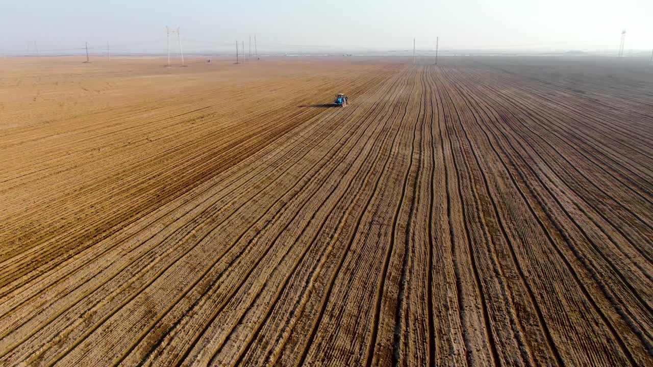 Combined Tractor Plowing Field On Agricultural Landscape