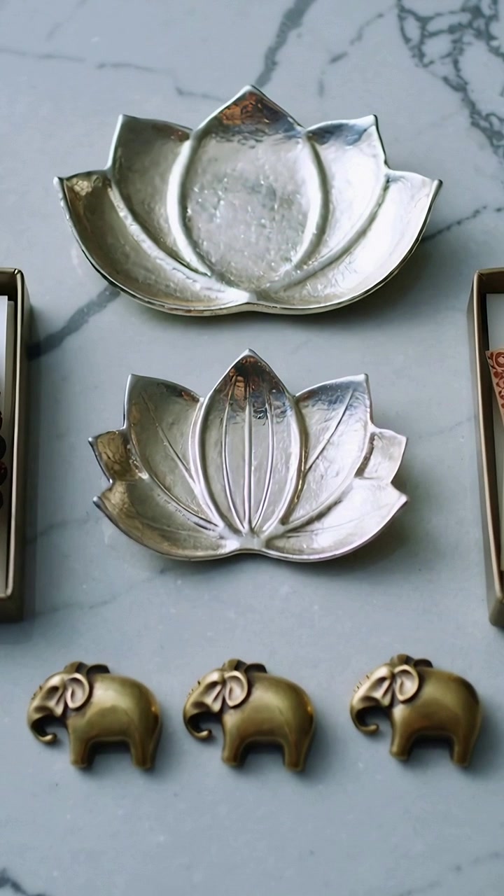Vertical video: Filming top cam revealing details of lotus dishes, elephants, beads, cash on marble