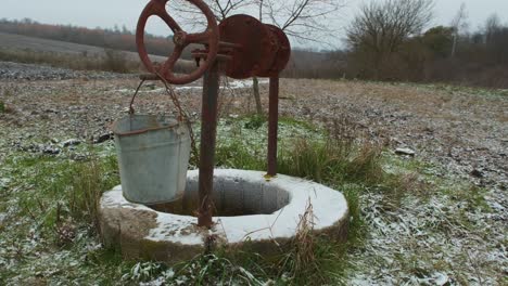 an old water well on rural homestead. an abandoned well in the middle of field in deep autumn.