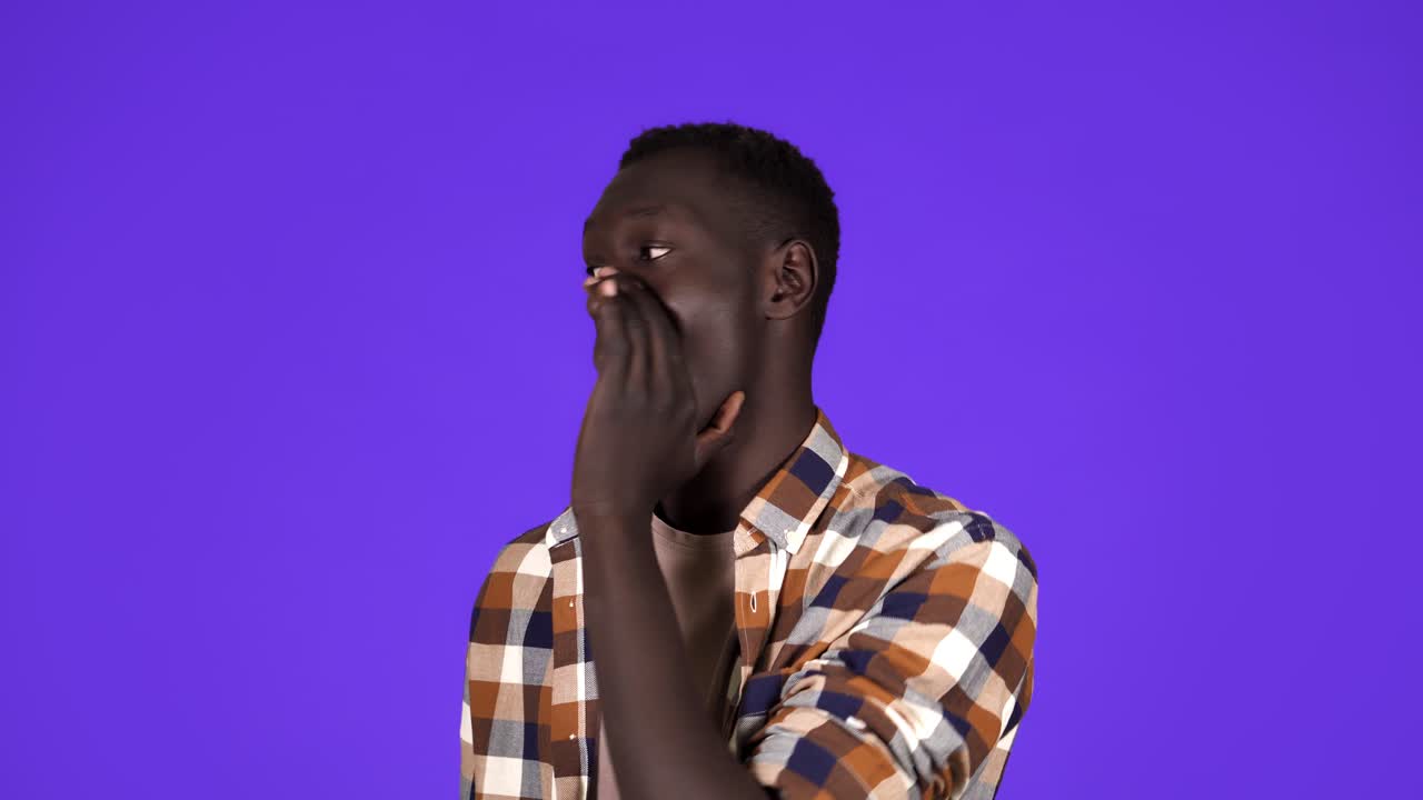 African american man making loud announcement at copy space, holding hand near his open mouth over blue background, side view