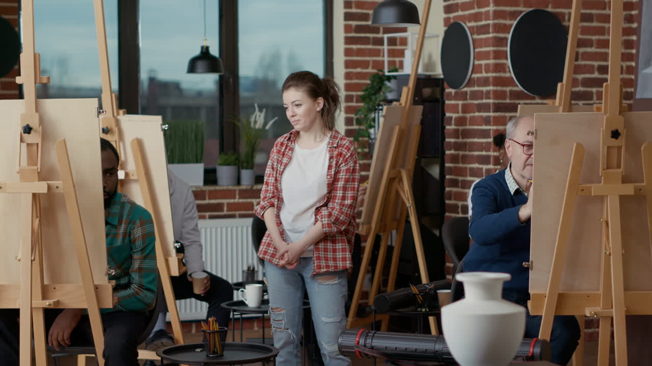 Art lesson teacher supervising students drawing vase model