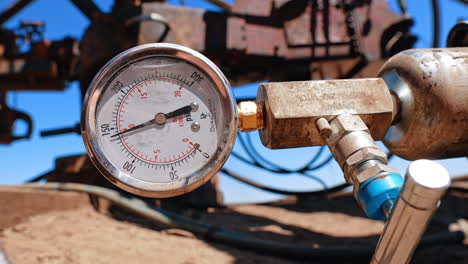 faucet and monometer attached to the metal cylinder. drilling equipment at oil industry site. close up.