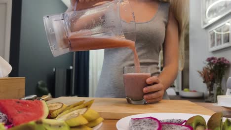 una mujer preparando un batido.