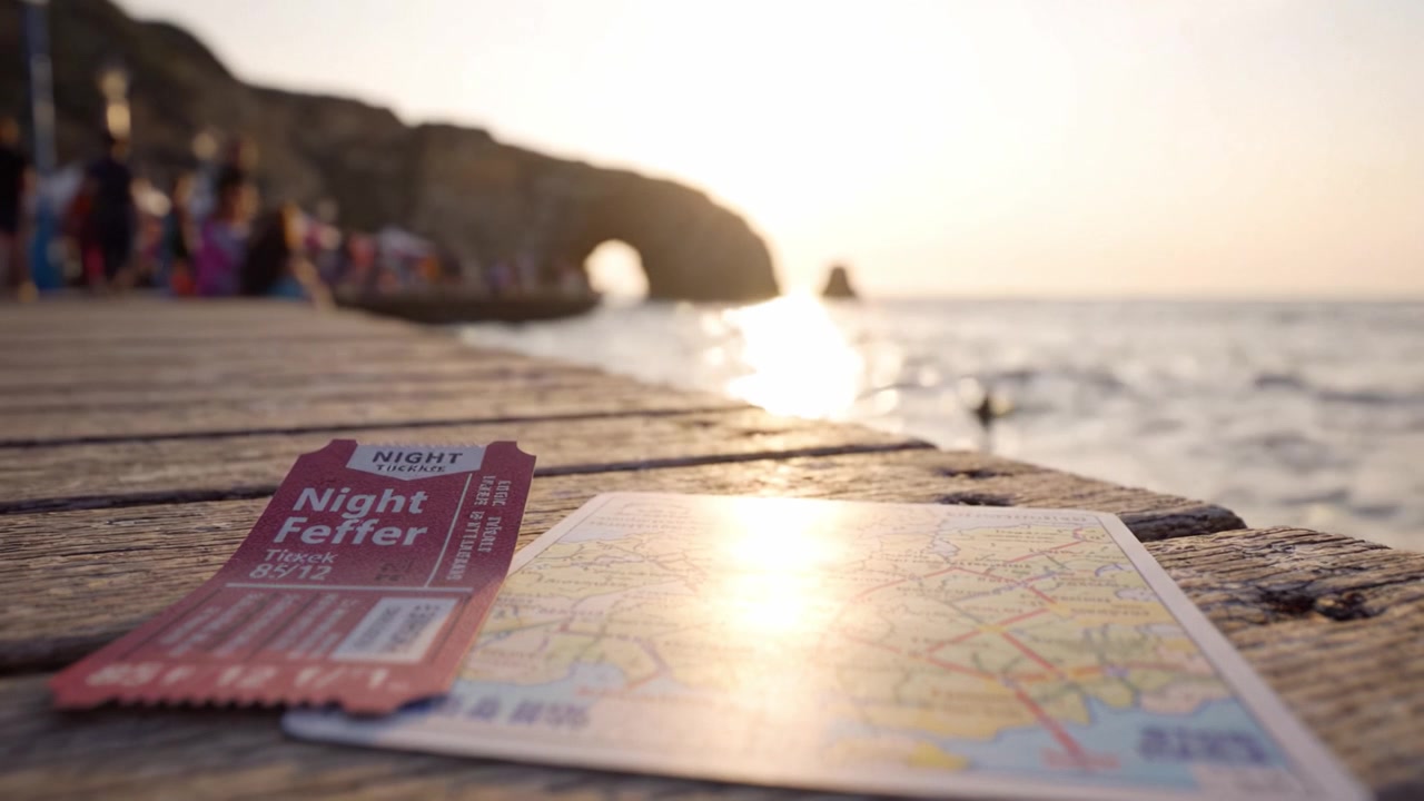 Noite de verão à beira-mar: Uma vista panorâmica com pôr do sol, bilhete e mapa, destacando aventura e exploração em um local costeiro.