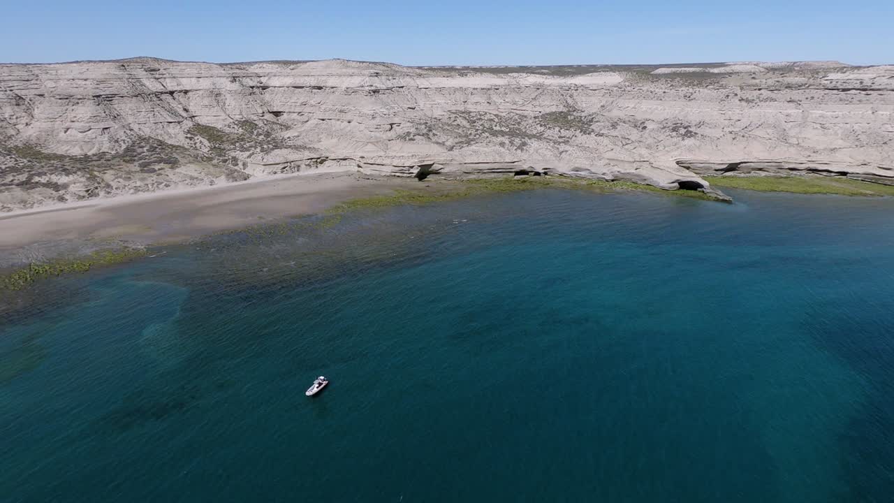 un barco turístico flotando por el hermoso mar patagónico durante la puesta de sol - toma aérea