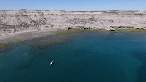 A-Tour-Boat-Floating-By-The-Beautiful-Patagonian-Sea-During-Sunset---Aerial-Shot