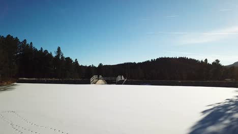 Huge-frozen-white-lake-in-Colorado,-drone-flying-up-and-revealing-more-of-the-frozen-lake