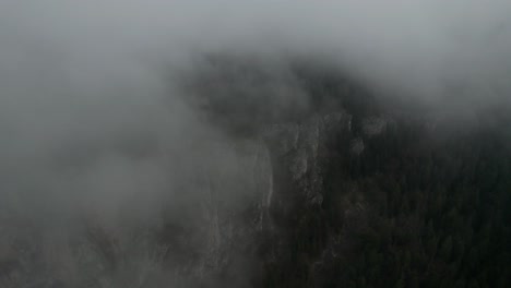 Still-shot-of-clouds-passing-by-mountain-rocks-view-with-trees