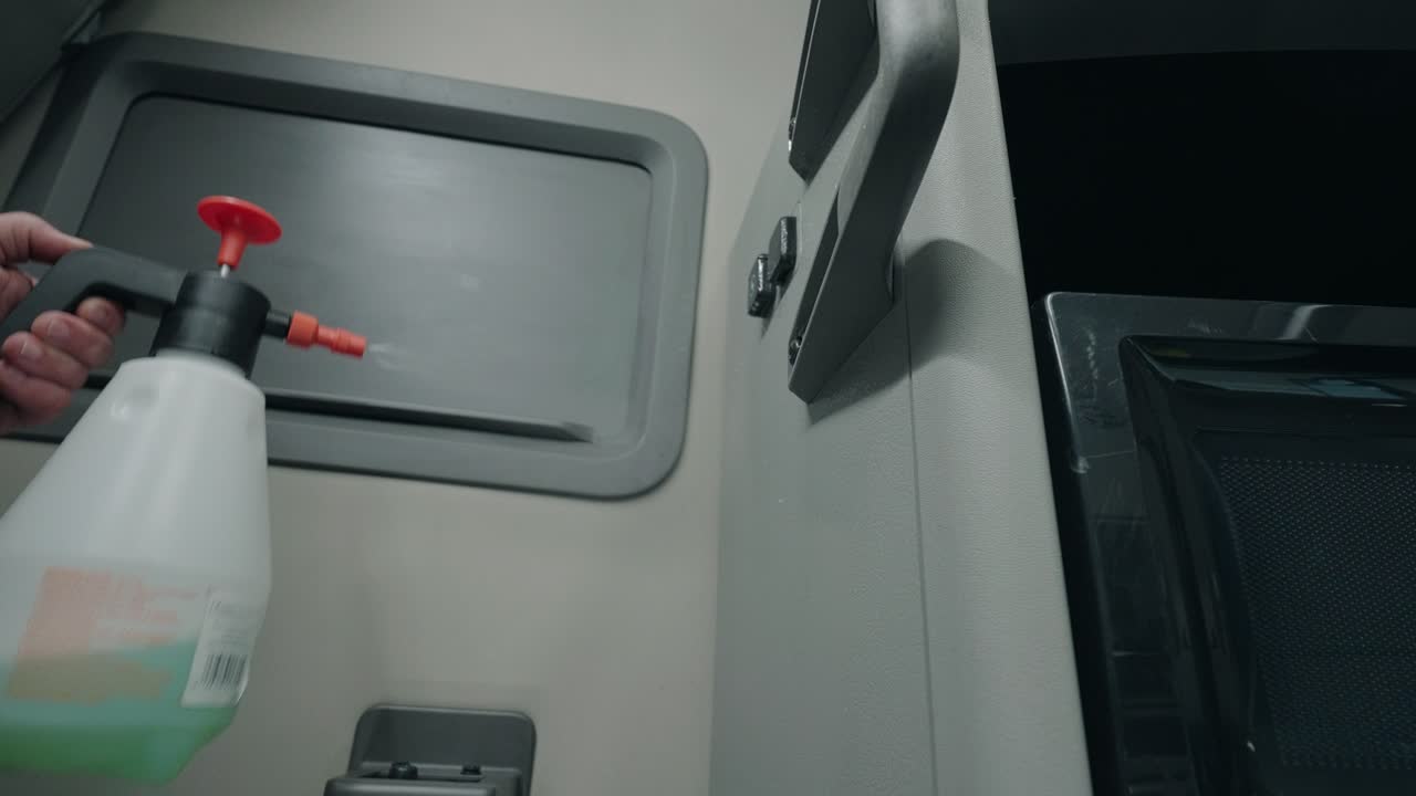 Hand dispensing soap from a container onto a truck floor - Truck Detailing and Cleaning