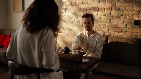 couple enjoying a tea ceremony in a cozy living room