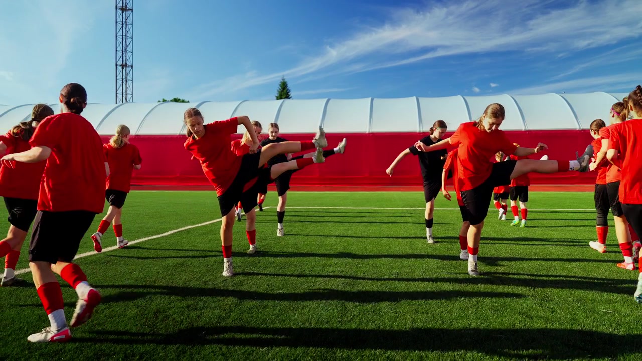 Jeugdvoetbalteam dat opwarmt op een buitenveld.