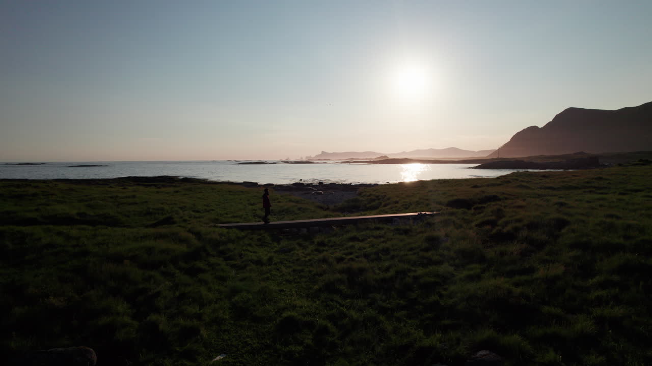노르웨이 북부의 놀라운 풍경 속 돌다리 위를 걷는 관광객