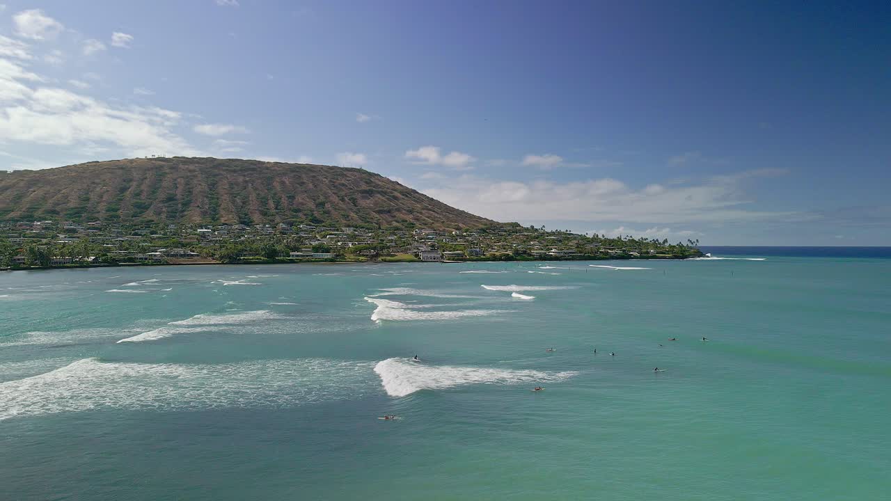 Vista aerea di surfisti in una giornata di sole hawaiana con cieli azzurri.