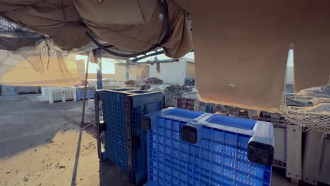 fishing warehouse outdoor environment, moving through covered stock plastic boxes aimed for keeping the fish cached