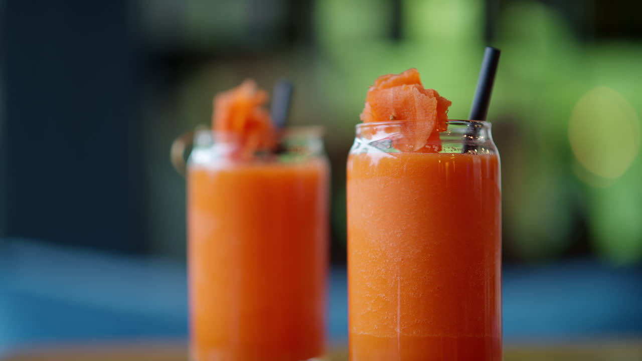 Two glasses of carrot juice, on the table at a restaurant
