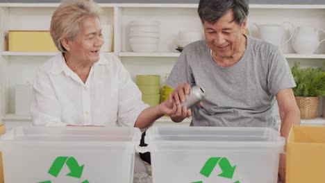 senior people helping to separate plastic bottle into recyclable bin at home together.