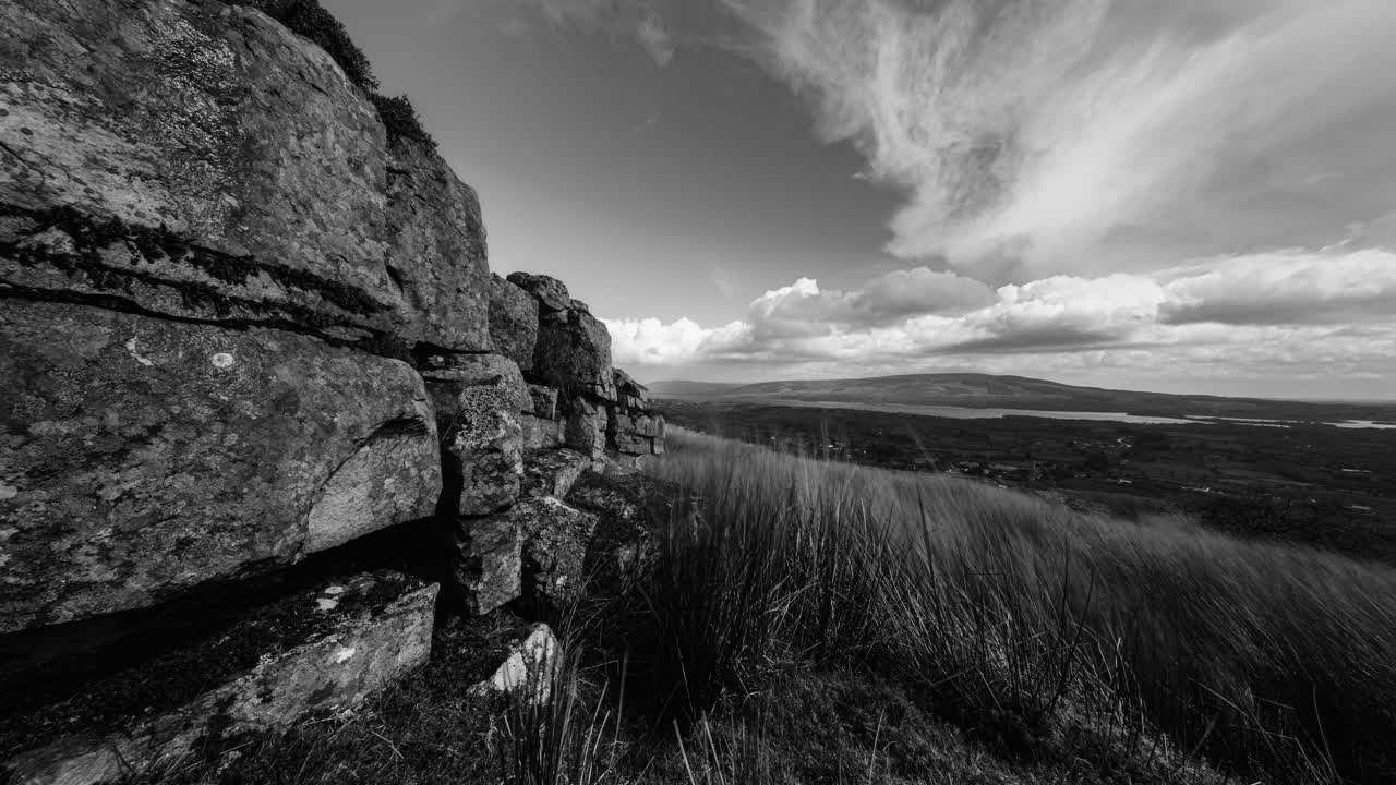 Black and white landscape with rock and clouds